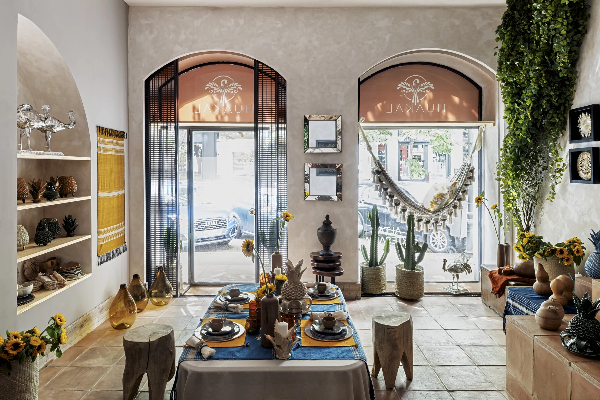 Entrada de Huakal Madrid con arcos, celosía metálica, mesa puesta con menaje artesanal mexicano y vegetación natural diseñado por huuun