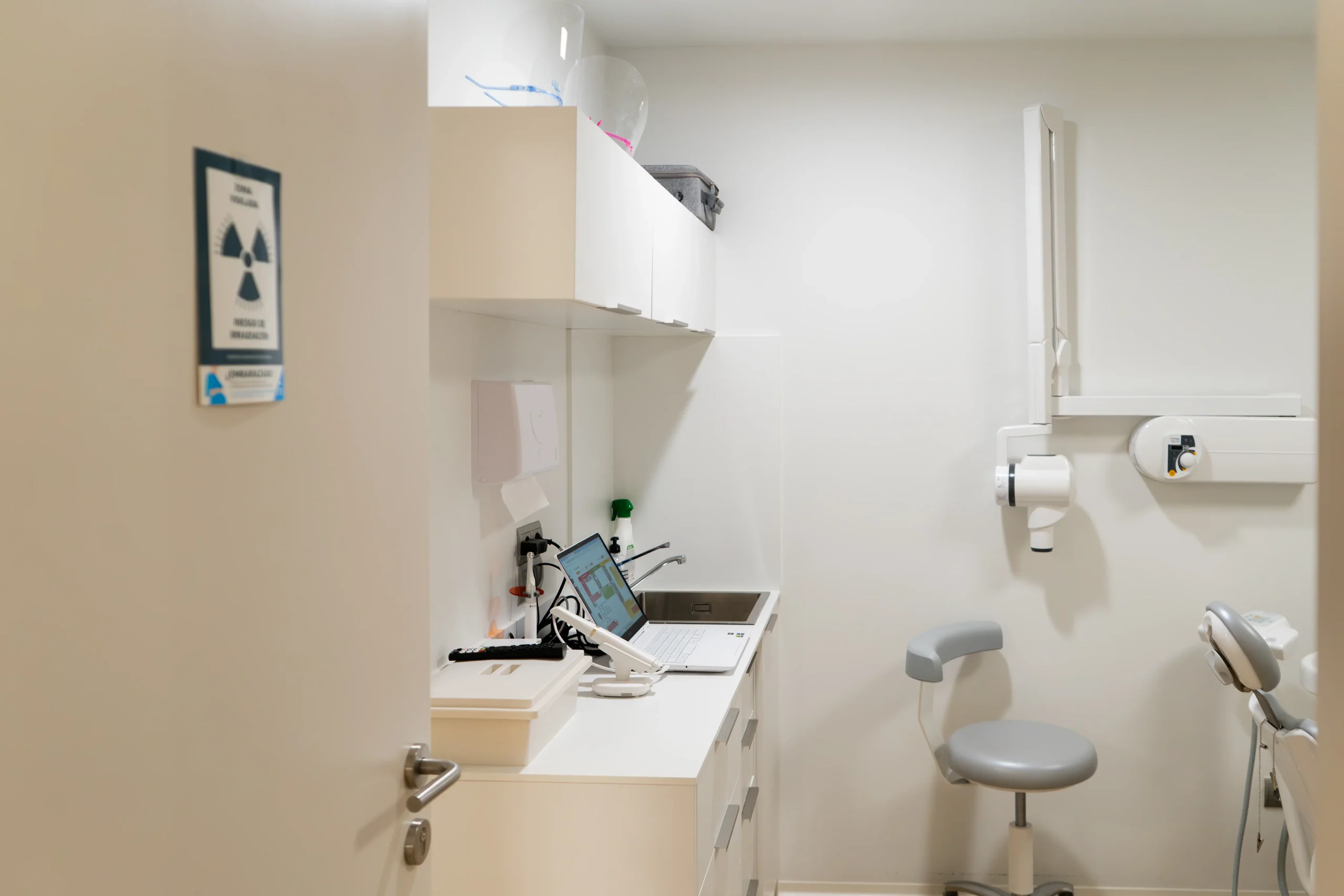 Sala de tratamiento de Dentalios en blanco, con sillón dental, equipo de radiografía panorámica y mobiliario clínico