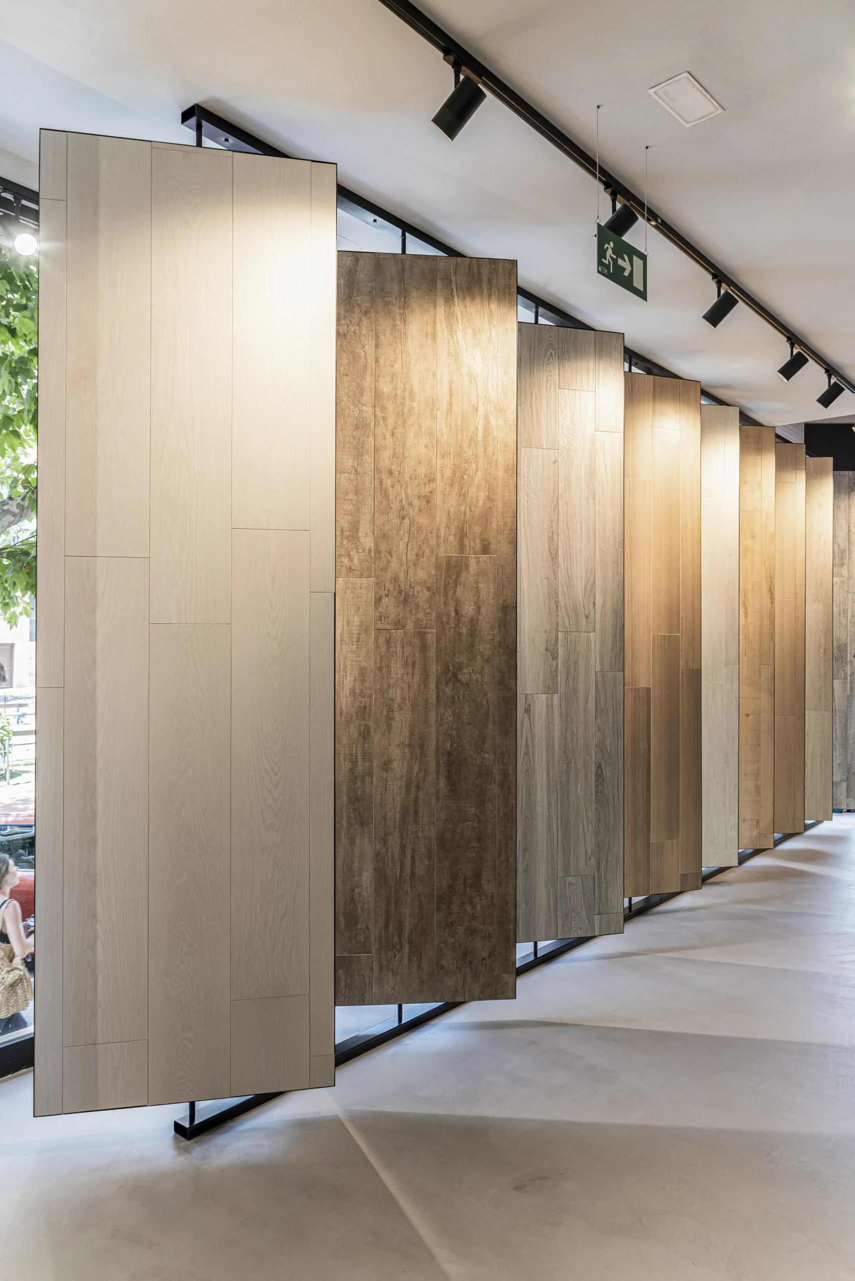 Fila de paneles cerámicos imitación madera en distintos tonos sobre soportes giratorios en la tienda SALONI de Alicante