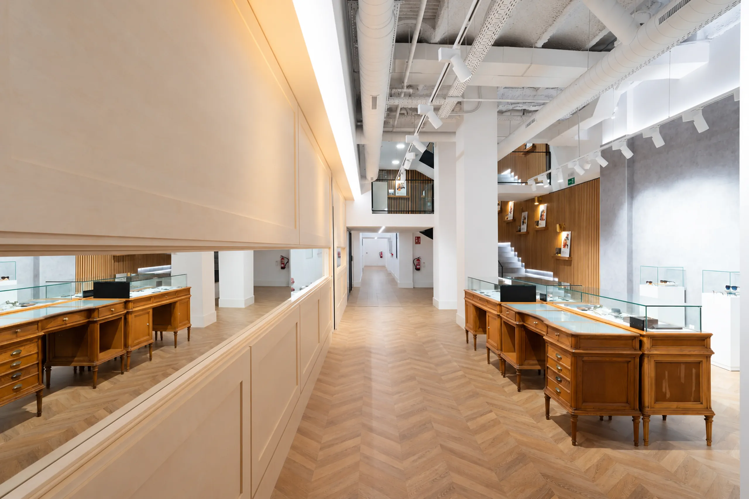 Flagship de óptica Cottet en Barcelona: mostradores de madera, vitrinas de cristal y parquet en espiga