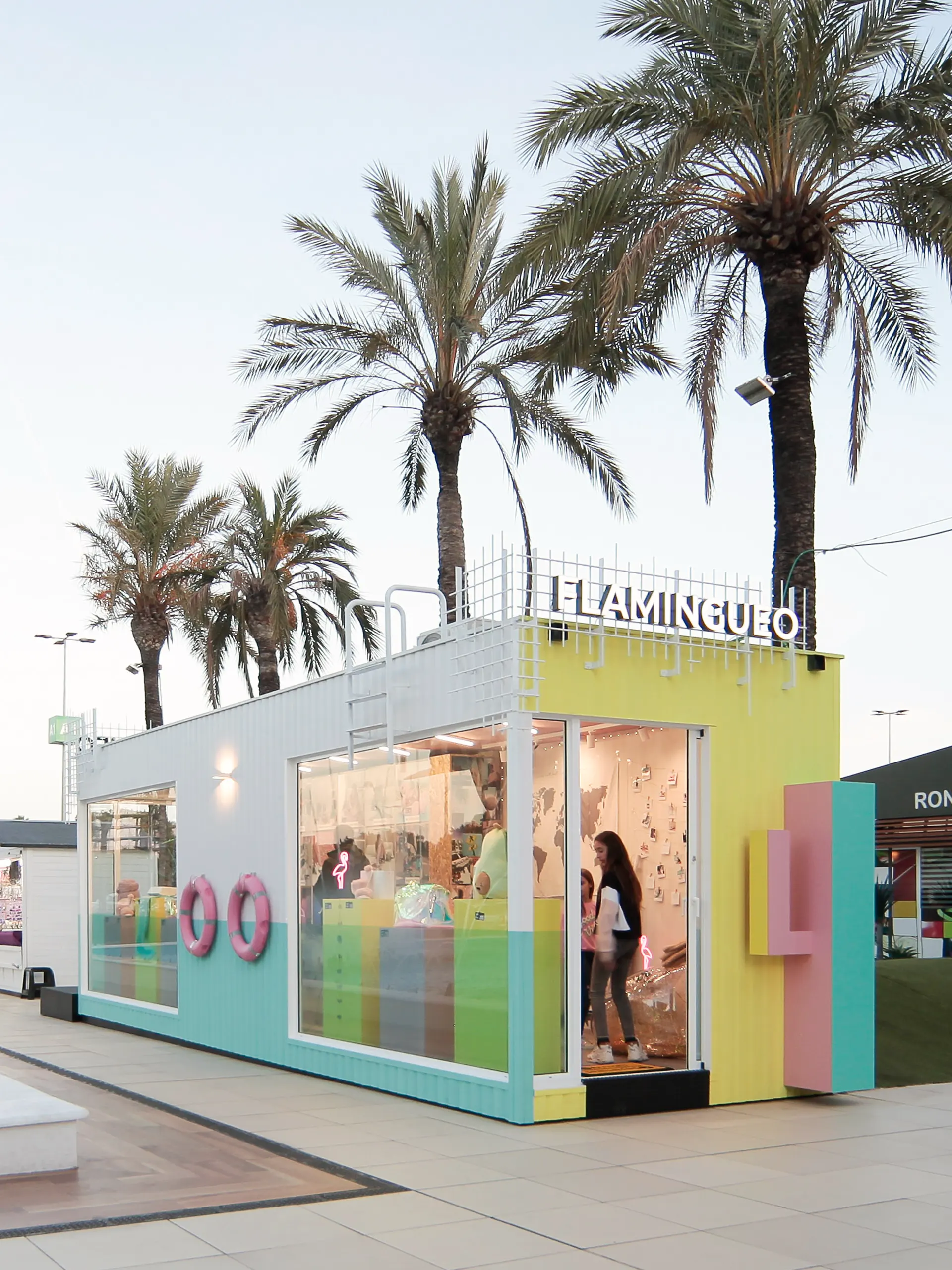 Alzados en color del contenedor: escaparates, acceso con cactus y fachada con mural