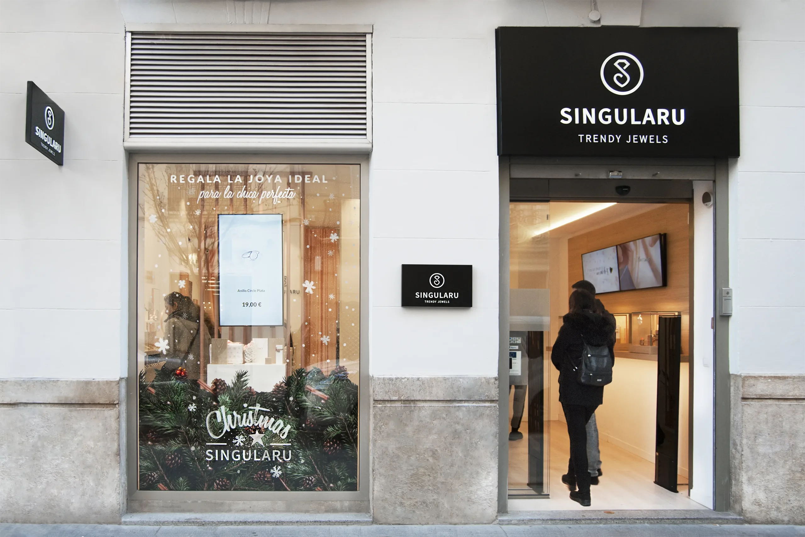 Fachada de Singularu en la calle con escaparate navideño «Regala la joya ideal» y puerta de entrada