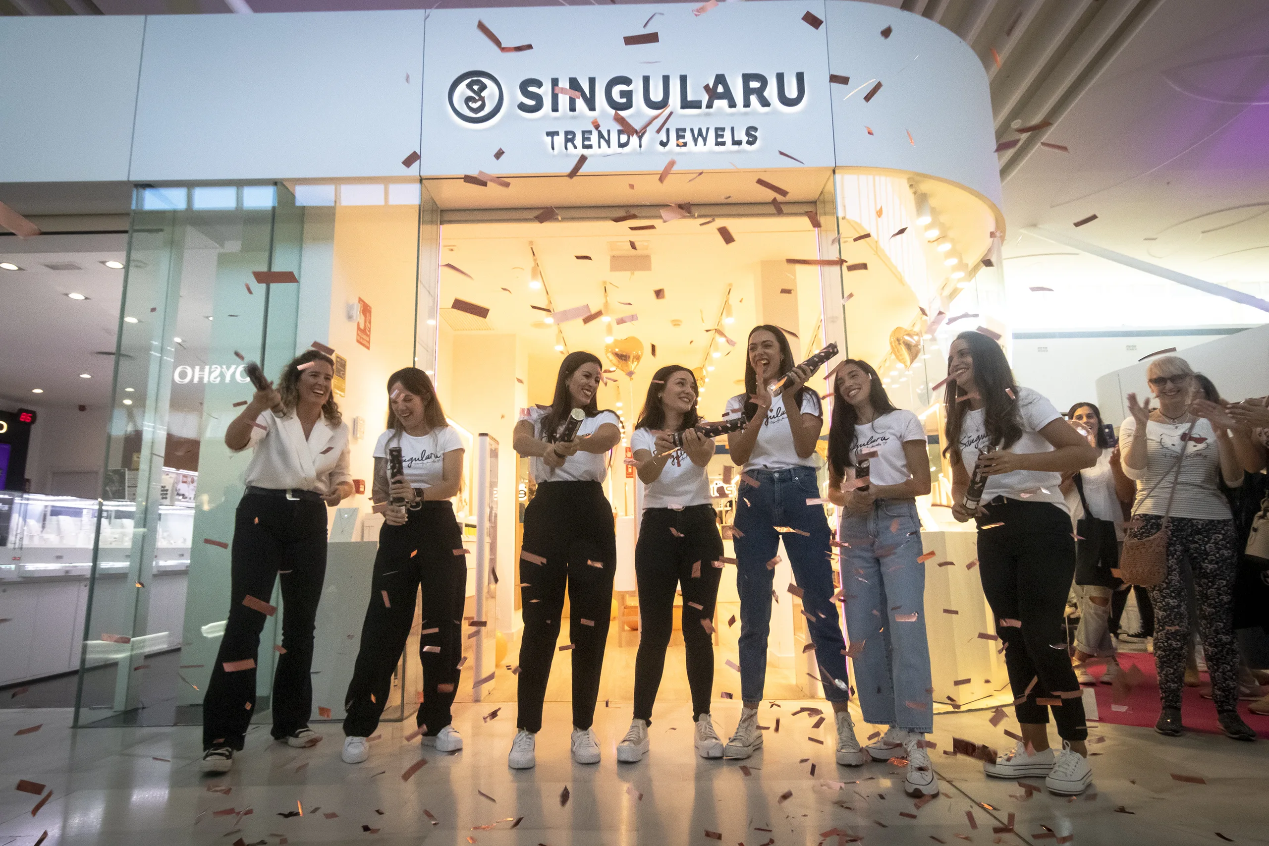 Equipo de Singularu lanzando confeti en la inauguración de una tienda en un centro comercial